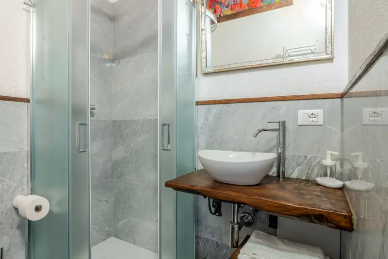 Bagno in marmo grigio con doccia