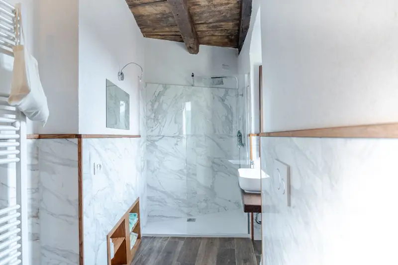 Bagno in marmo bianco con doccia walk-in