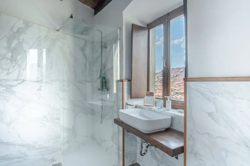 Bagno in marmo con vista sui tetti del borgo