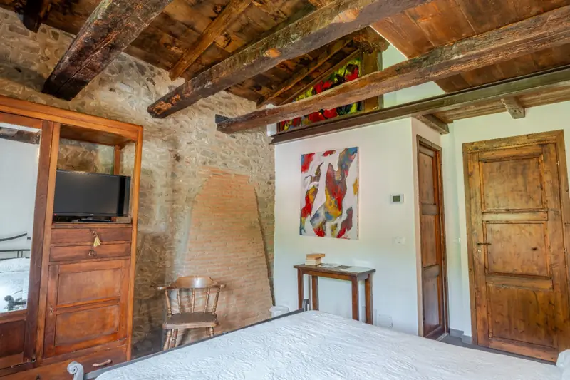 Camera con travi antiche e quadro d'autore