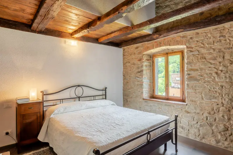 Camera in pietra con letto in ferro
