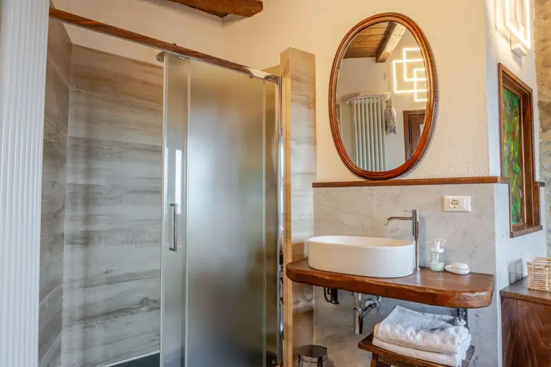 Bagno con doccia e specchio ovale