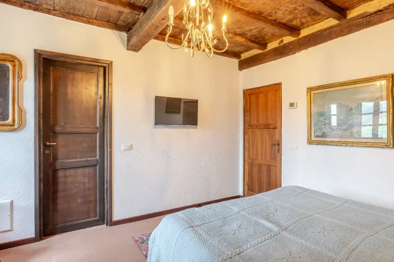 Camera con comò intarsiato e vista sulla valle